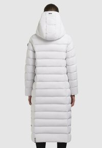 Lang, hvid dunjakke med hætte, med en kviltet design, lige skæring og elastiske manchetter, der går ned til midt på læggen.