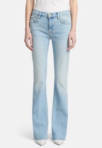 Jeans flare azzurri chiari con un effetto sbiadito. Presentano un design tradizionale a cinque tasche e chiusura con bottone. Realizzati in tessuto denim.