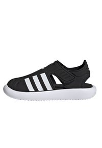Sorte slip-on sko laget av syntetisk materiale, med utskårne seksjoner og tre hvite striper på siden, med en hvit gummisåle.