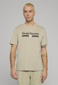Beżowy bawełniany t-shirt z krótkimi rękawami, z czarnym nadrukiem "Sergio Tacchini" i logo, gładka faktura, standardowy krój.