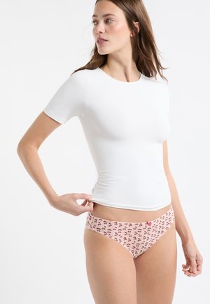 Biały t-shirt z krótkim rękawem w połączeniu z jasnoróżowymi majtkami w wzór z wiśniami oraz czerwonym kokardką na pasku.