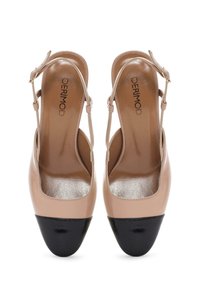 Beżowe skórzane buty na obcasie typu slingback z błyszczącą czarną osłoną palców, niskim obcasem i delikatnym paskiem na kostkę, z teksturowanym wnętrzem.
