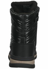 Bottine noire imperméable avec un dessus brillant et rembourré. Dispose d'une douce doublure en fourrure, d'une semelle en caoutchouc robuste et d'une sangle Velcro pour un ajustement sécurisé.