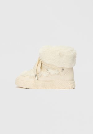 Elefántcsont színű bokacsizma műszőrme díszítéssel, texturált fűzős kialakítással, gumitalppal és virágmintás díszítéssel a talpon.