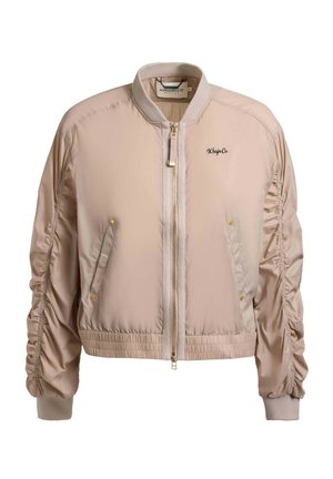 Jasnobeżowa bomberka z przednim zamkiem błyskawicznym, marszczonymi długimi rękawami, dwoma skośnymi kieszeniami z zatrzaskami oraz małym logo "Khujico" na piersi.