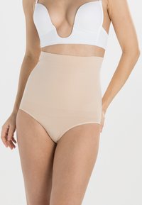 Beige korkeavyötäröiset muotoilevat alushousut, jotka on valmistettu sileästä elastisesta materiaalista. Niissä on leveä vyötärönauha ja saumatonta muotoilua, joka takaa sujuvan istuvuuden.