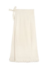 Jasnokremowa spódnica robocza z zapięciem na boczną kokardę i frędzlami, wykonana z fakturowanej tkaniny.