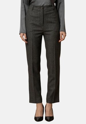 Pantaloni grigi su misura con sottili righe verticali, vita alta, chiusura anteriore con bottone e taglio dritto, abbinati a una blusa a maniche lunghe.