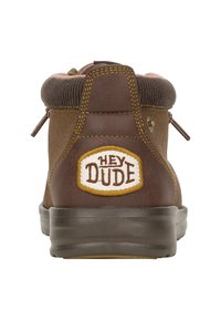 Brązowy botek za kostkę z miękkim brązowym kołnierzem, wzorzystym szwem i okrągłą naszywką z logo "HEY DUDE" na pięcie; gumowa podeszwa.