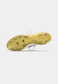 Cleat with a yellow outsole, transparent studs, and textured detailing. Upper features white design with branding on the side and heel.