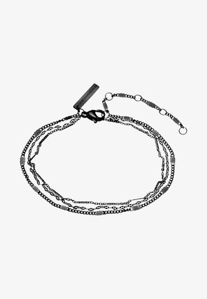 Multiple layered black metal chains with irregular silver accents, featuring a lobster clasp and a rectangular tag.