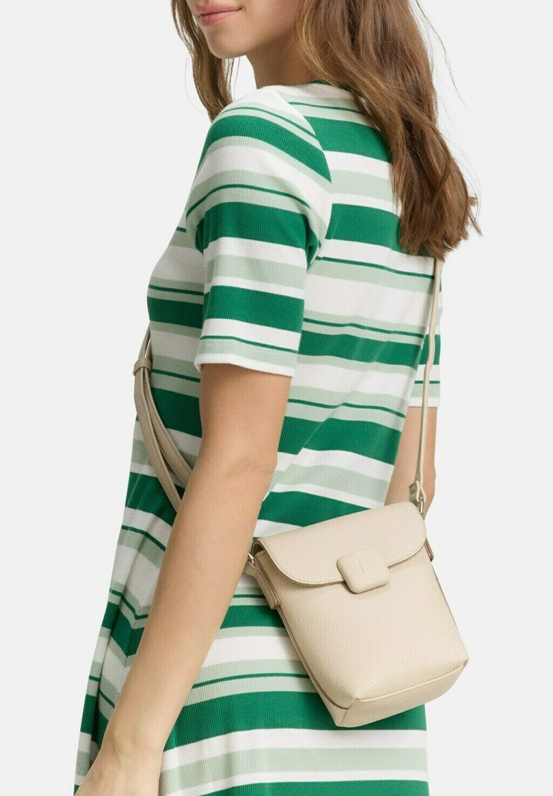 Beżowa torebka na ramię z teksturowaną powierzchnią, prostokątnym kształtem i klapką. Regulowany pasek oraz minimalne akcenty metalowe.