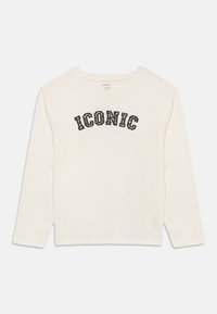 Μπλούζα με μακριά μανίκια σε κρεμ χρώμα από βαμβάκι με στρογγυλή λαιμόκοψη. Φέρει τη λέξη «ICONIC» σε μαύρα και animal print γράμματα στο στήθος.