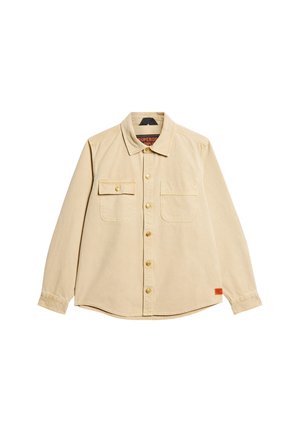 Beige Hemd mit Knopfleiste aus Baumwolle, ausgestattet mit zwei Brusttaschen, goldenen Knöpfen und einem abgerundeten Saum. Das Etikett im Kragen trägt die Aufschrift "Superdry".