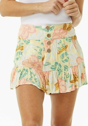 Floral gemusterte Shorts mit vier Holzknöpfen vorne und gerafftem Saum, kombiniert mit weißem ärmellosem Oberteil.