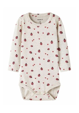Kremowy pajacyk niemowlęcy z długim rękawem, z różowymi biedronkami i czerwonymi serduszkami, zapinany na zatrzaski u dołu.