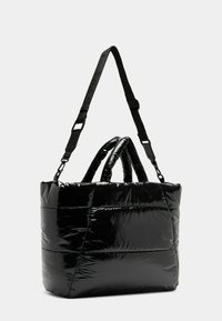 Borsa a spalla nera trapuntata con finitura lucida, dotata di due manici superiori e di una tracolla rimovibile. Design con pannelli testurizzati.