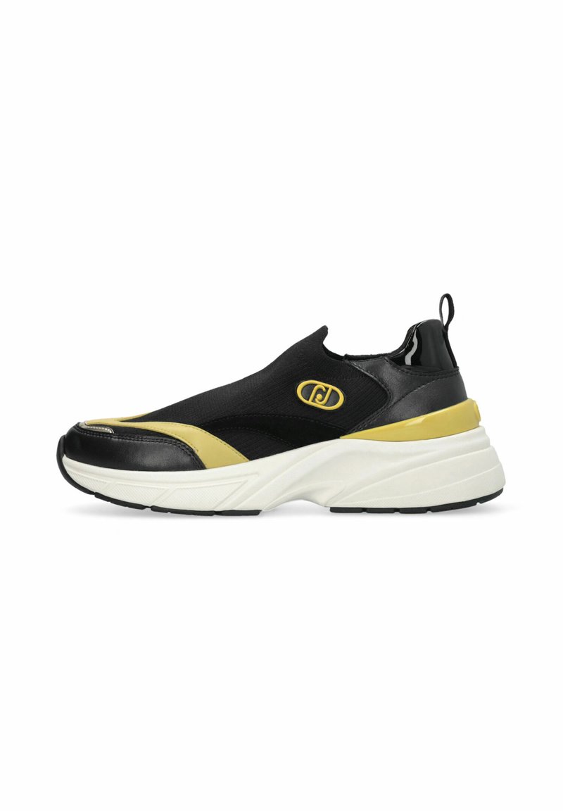 Sneaker noir sans lacets avec des accents jaunes, une tige texturée en polyester, une semelle intermédiaire blanche rembourrée et un talon noir brillant.