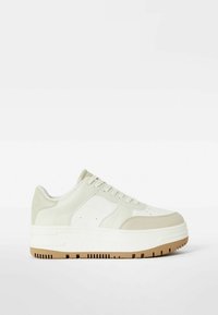 Světle zelené kožené tenisky s kulatou špičkou, perforovanými detaily a vícvrstvou bílou a světlě hnědou podrážkou s texturovaným povrchem.