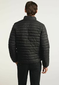 Czarna kurtka puchowa z poziomym pikowaniem, wysokim kołnierzem i elastycznymi mankietami, wykonana z lekkiego, izolowanego materiału.