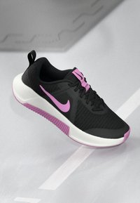 Schwarzer Athletikschuh mit pinken Akzenten, ausgestattet mit einem Mesh-Obermaterial, gepolstertem Schuhsohle und einer strukturierten Gummisohle für besseren Halt.