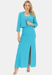 Turkusowa dwu częściowa sukienka z długą spódnicą z rozporkiem z przodu oraz krótką kurtką z rękawami do 3/4. Gładka tekstura.