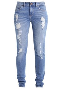 Jeans de mezclilla azul claro con detalles desgastados y desgastes estratégicamente colocados. Corte ajustado con un diseño clásico de cinco bolsillos y cierre de botón.