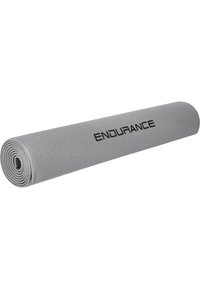 Grå yogamatta med en tekstureret overflade, rullet sammen. Har ordet "ENDURANCE" trykt i sort langs siden.
