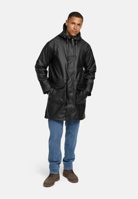 Zwarte waterdichte parka met een capuchon, ritsluiting, verstelbare trekkoorden, twee voorzakken en een ontwerp dat tot halverwege de dij komt.