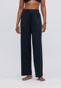 Mørkeblå pysjamasbukser med et subtilt geometrisk mønster, med elastisk midje og løs, vid ben-design for komfort.