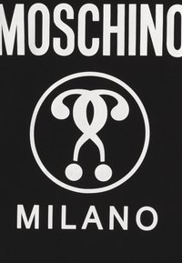 Černé tričko s velkým bílým potiskem loga zaoblených tvarů a textem "MOSCHINO MILANO" pod ním, psané tučným velkým písmem.