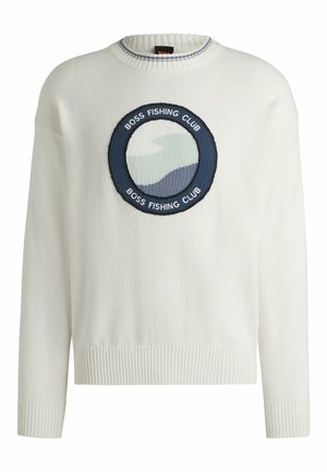 Witte gebreide trui met een ronde, marineblauwe geborduurde patch met de tekst "BOSS FISHING CLUB" en een golfontwerp in groene en blauwe tinten.