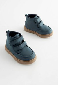 Bottines en synthétique bleu mi-haut avec deux bandes Velcro, semelles en caoutchouc beige et doublure intérieure douce et texturée.