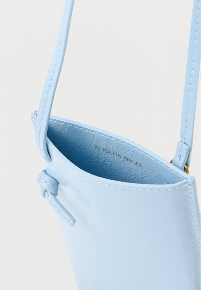 Ανοιχτό μπλε δερμάτινη τσάντα χιαστί με λεπτό ιμάντα, ορατή ραφή, λεπτομέρεια κόμπου στο πλάι και κείμενο "BY MALENE BIRGER" στο εσωτερικό.