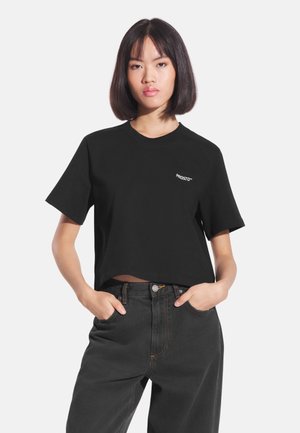 Czarny krótki t-shirt wykonany z bawełny, z okrągłym dekoltem i krótkimi rękawami. Posiada małe białe logo na lewej stronie klatki piersiowej.