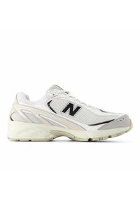 Valkoinen urheilukenkä verkkomateriaalista yläosassa, kaareva muotoilu, pehmustettu kaulus, musta "N"-logo ja kuvioitu kumipohja.