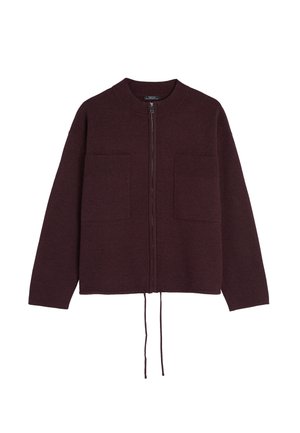 Burgundy vetoketjukauluspaita pitkillä hihoilla, jossa on ribbikuvio ja kaksi etutaskua. Helman sisällä on nyöri. Pehmeää neulemateriaalia.