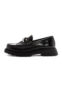Mocasines de cuero negro con herrajes decorativos, detalles de costura y suela de goma gruesa. Textura suave con acabado brillante y forma clásica.