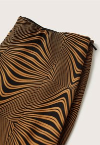 Tessuto nero con un motivo marrone ondulato. Presenta una chiusura a zip e una texture liscia. Il design crea un effetto visivo dinamico.