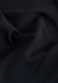 Black fabric with a smooth, matte texture, featuring soft drapes and subtle movement. No patterns or notable hardware details visible.