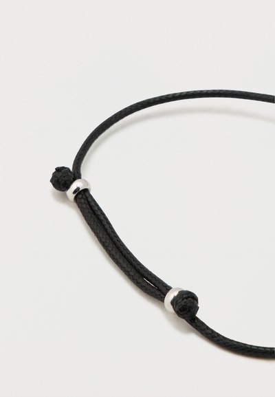 Black braided cord necklace featuring two textured knots and silver-tone metal accents, designed for adjustable length and durability.