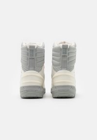 Botas de tobillo grises con cuellos acolchados, que cuentan con un suave forro interior, una suela gruesa y una etiqueta de logo en la parte posterior.