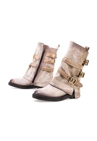 Beżowe zamszowe botki za kostkę z zamkiem błyskawicznym, trzema dekoracyjnymi paskami z klamrami, okrągłym noskiem i niską czarną gumową podeszwą.