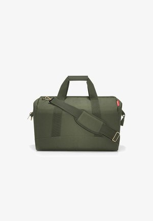 Bolsa de viaje de tela verde con asas dobles, correa de hombro ajustable, acentos de hardware marrón, forma rectangular y textura suave.