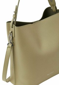 Sac fourre-tout en cuir vert avec une surface texturée, une bandoulière et des accessoires en argent. Présente un design minimaliste avec une ouverture sur le dessus.