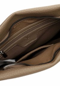 Interior de un bolso de cuero marrón con un acabado texturizado, que incluye un bolsillo con cremallera y un forro de tela suave. Se observan múltiples compartimentos.