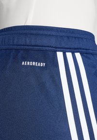 Mørkeblå sports-shortser i et struktureret stof med hvide tre-stribede accenter og et "AEROREADY"-logo på taljen.