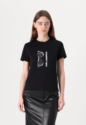 T-shirt noir avec un design graphique d'un corset et le texte "KARL LAGERFELD" en blanc. Manches courtes et coupe confortable.