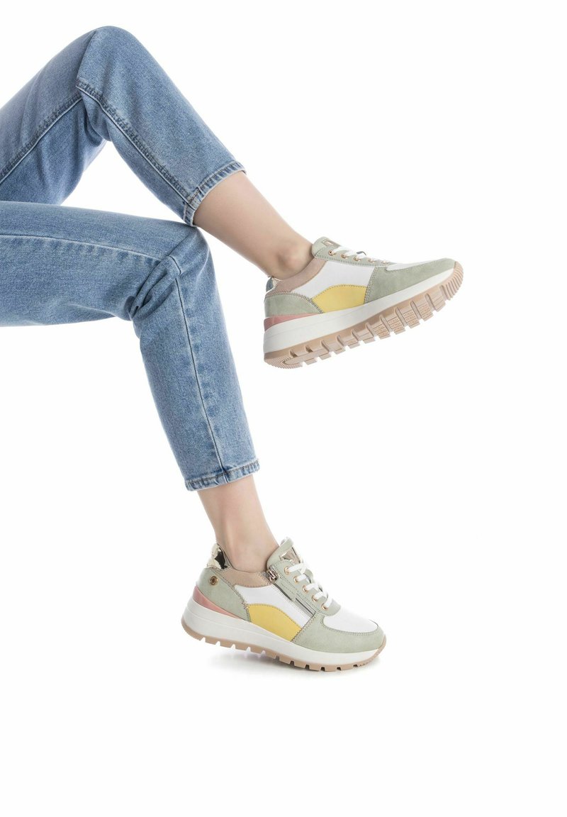 Zapatilla multicolor en verde, amarillo, rosa y blanco. Hecha de ante y malla, cuenta con una suela texturizada y cierre de cordones.
