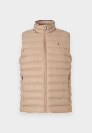 Beige puffer vest med høy krage, horisontal quilted design, front glidelås og to sidelommer. Har en liten logo på brystet.